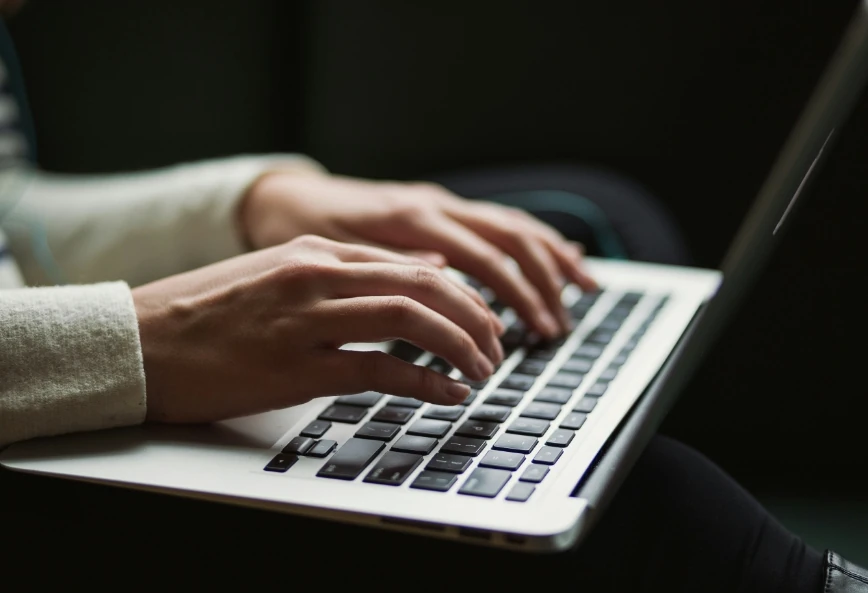 Person typing on a laptop, reading 5 Minutes With Mark